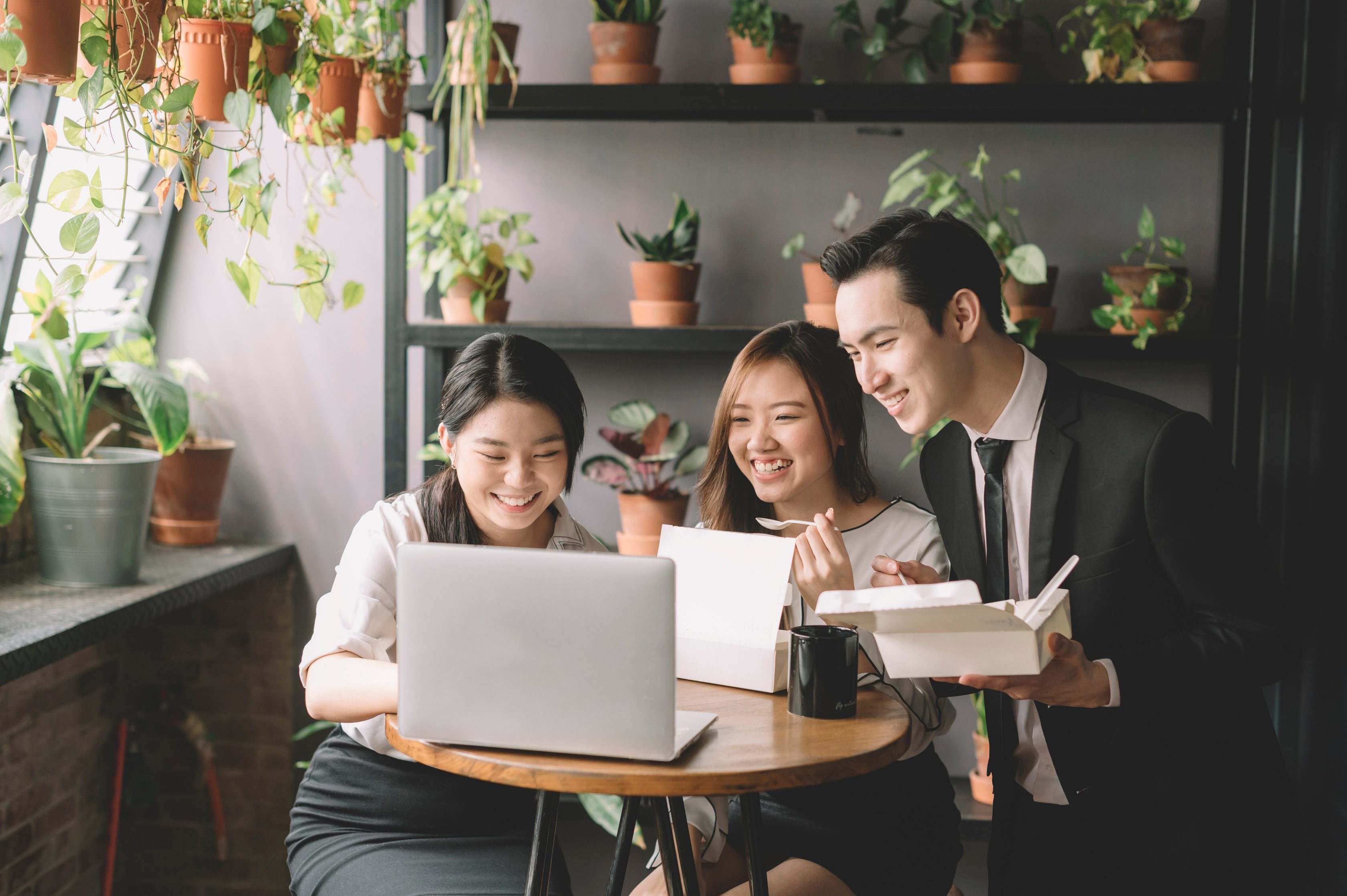 people discuss in front of a laptop